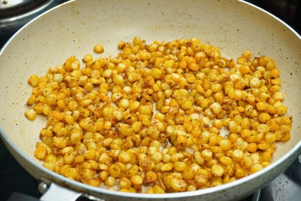 garlic butter masala corn frying in pan