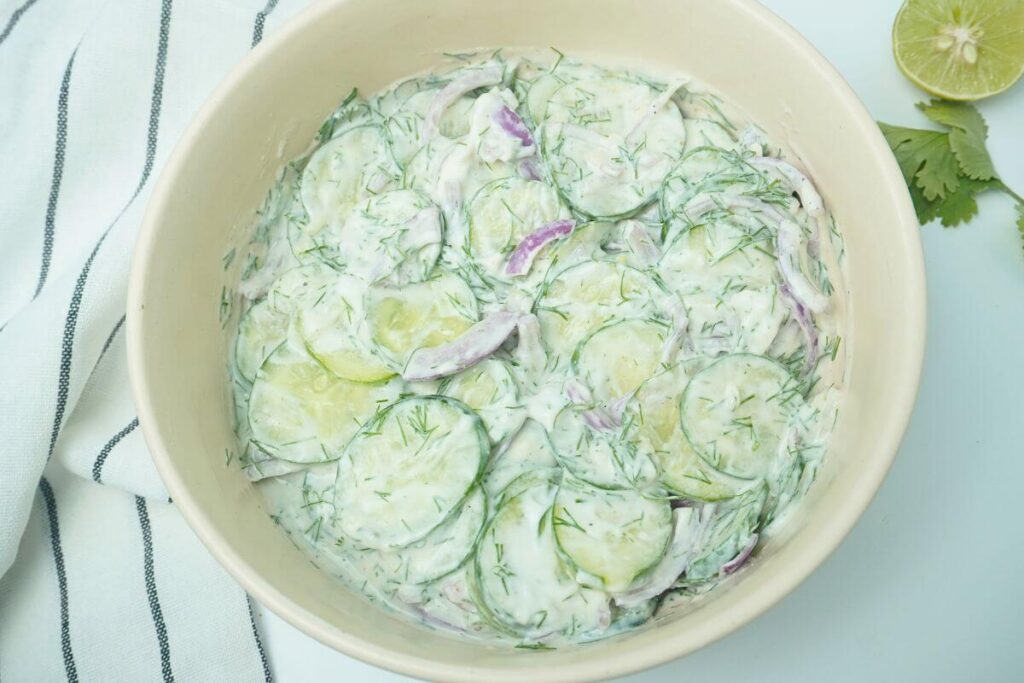 creamy cucumber salad mixing