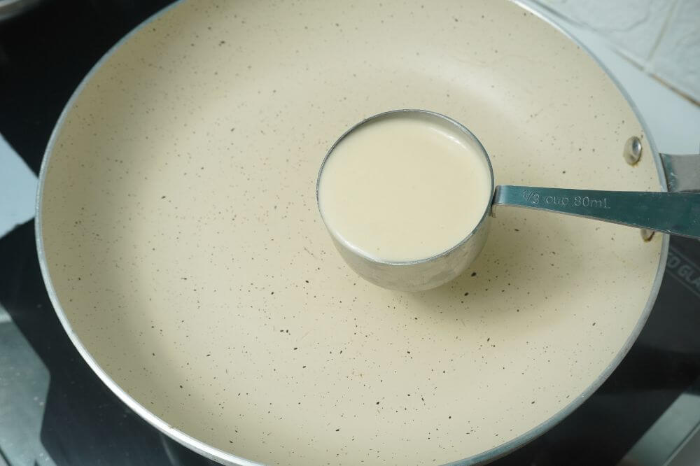fluffy pancakes cup of batter going in pan