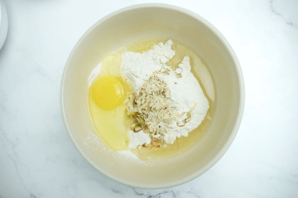 add flour, egg, chopped nuts, baking soda, salt, and oil